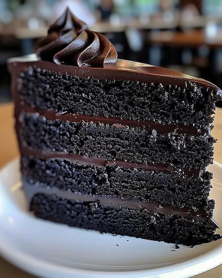 A slice of decadent Black Velvet Cake topped with cream cheese frosting.