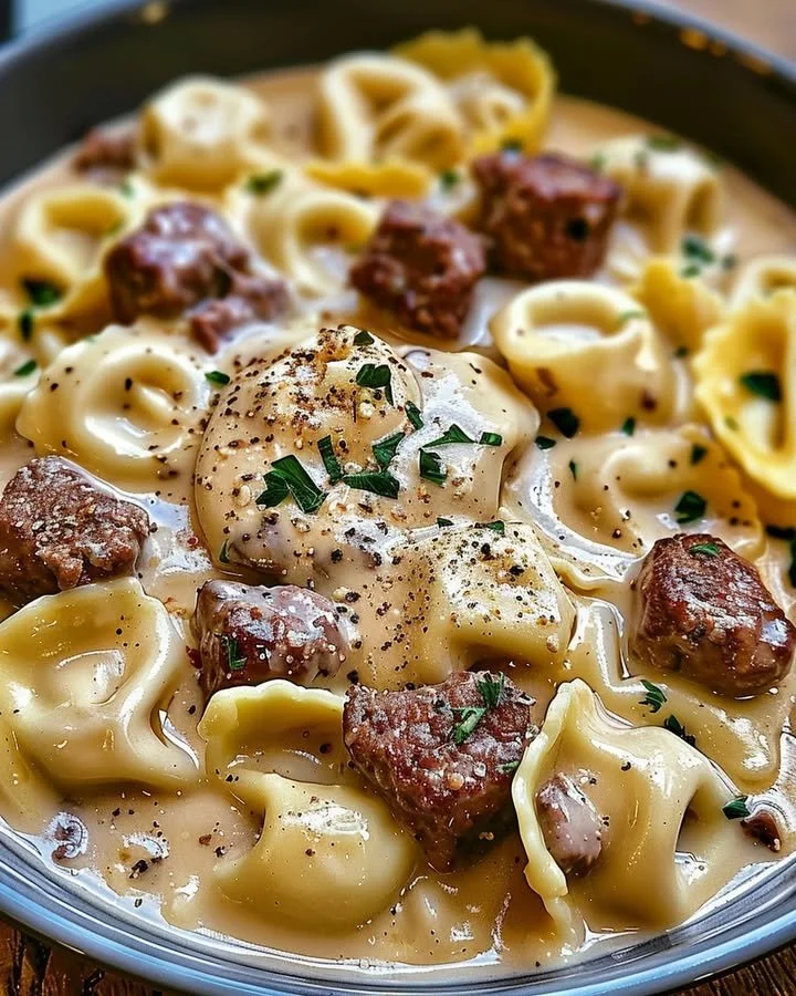 Delicious cheesesteak tortellini in rich provolone sauce served in a bowl.