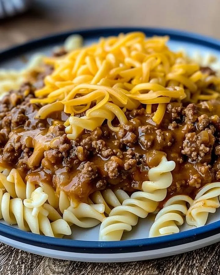 Bowl of cheesy sloppy cheeseburger pasta topped with cheese and herbs