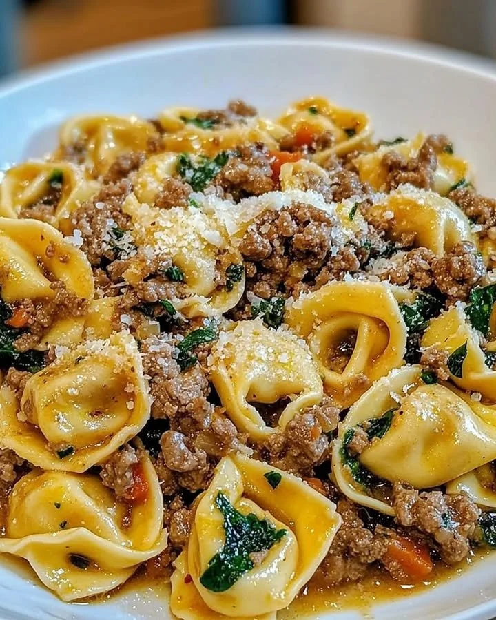 Plate of garlic butter beef tortellini garnished with herbs