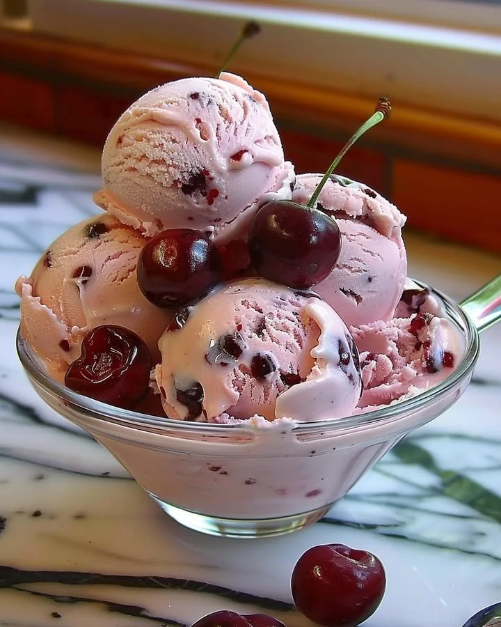 Bowl of homemade cherry ice cream topped with fresh cherries
