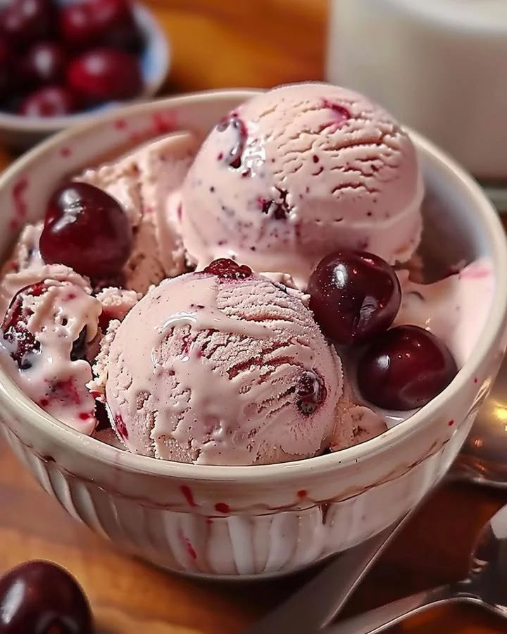 Homemade cherry vanilla ice cream in a bowl with fresh cherries on top