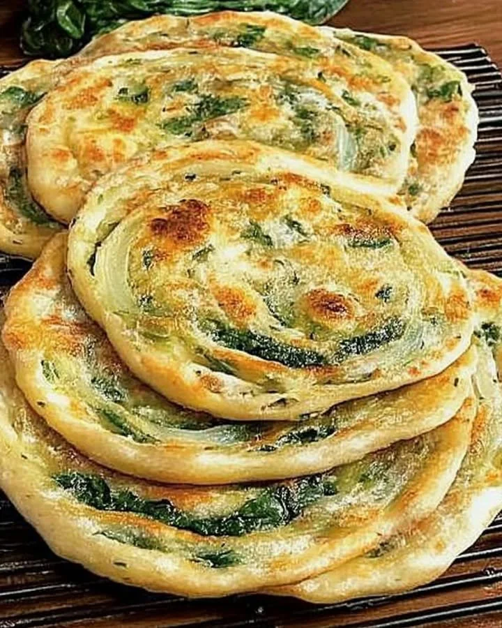 Pan-fried green onion and spinach flatbread on a rustic plate