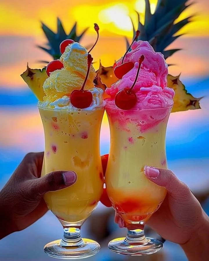 Colorful Rainbow Sherbet Piña Colada cocktail in a glass surrounded by tropical fruits.