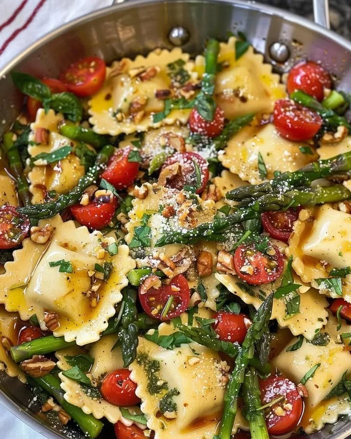 Plate of ravioli with tomatoes, asparagus, garlic, and herbs