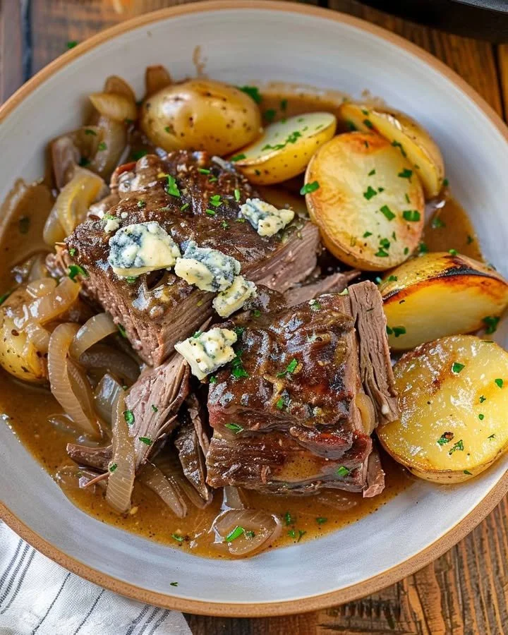 Savory chuck roast topped with rich blue cheese gravy on a serving plate.