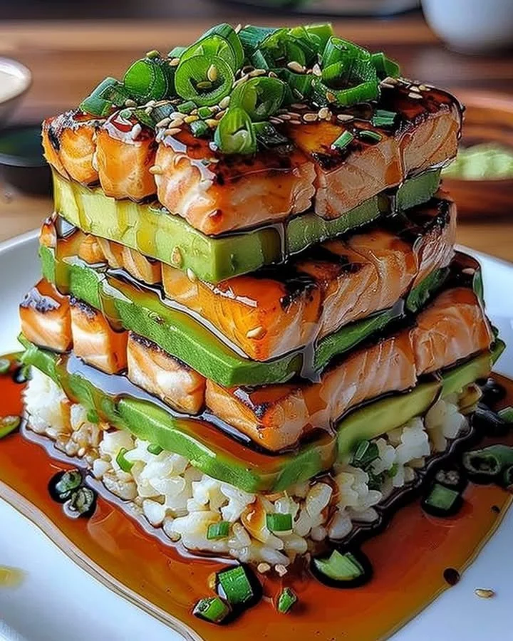 Teriyaki salmon avocado rice stack with fresh ingredients and vibrant presentation