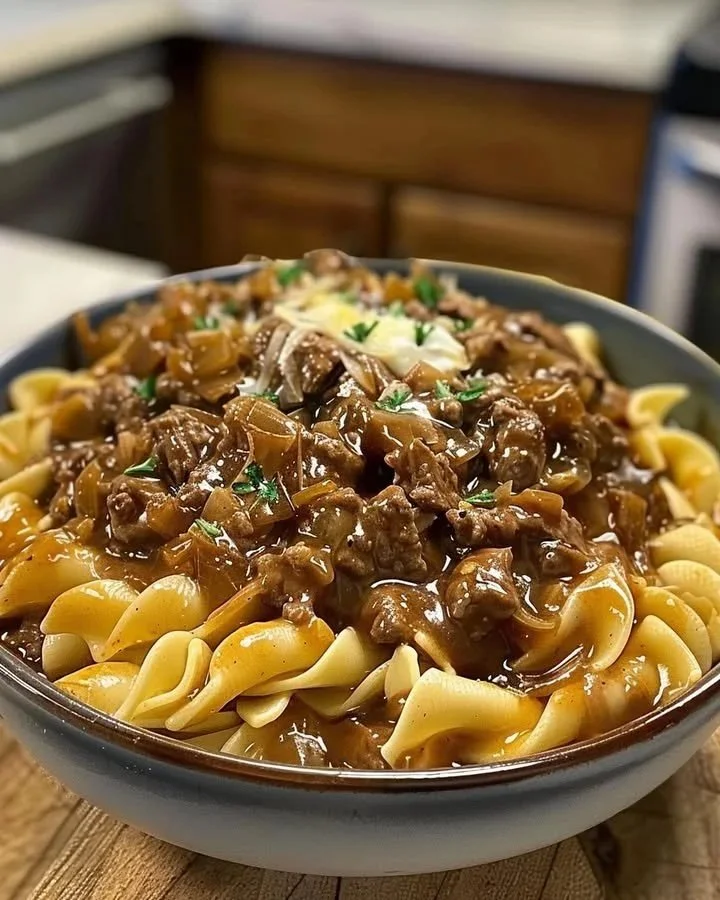 Delicious plate of Beef with French Onion Noodles topped with melted cheese