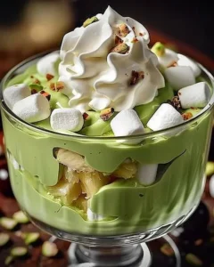 Delicious pistachio pudding topped with fresh pineapple slices served in a dessert bowl.